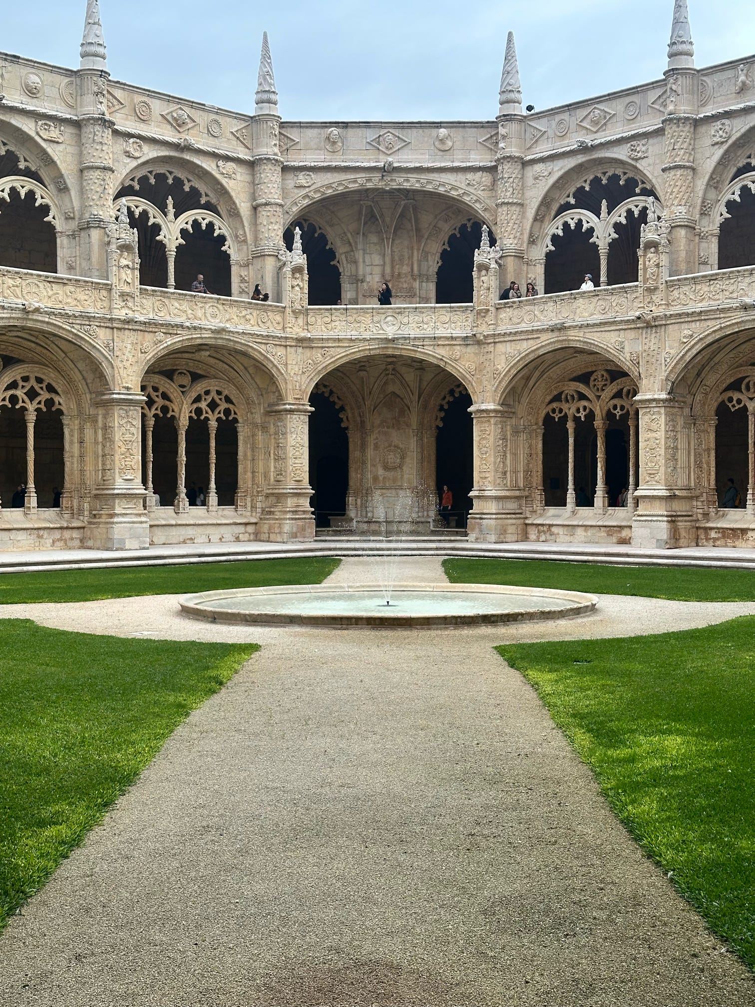 Ornate stone cloister courtyard with arches and fountain in Portugal