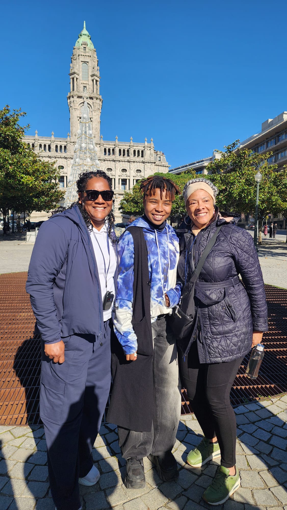Travelers smiling together in a historic city square in Portugal