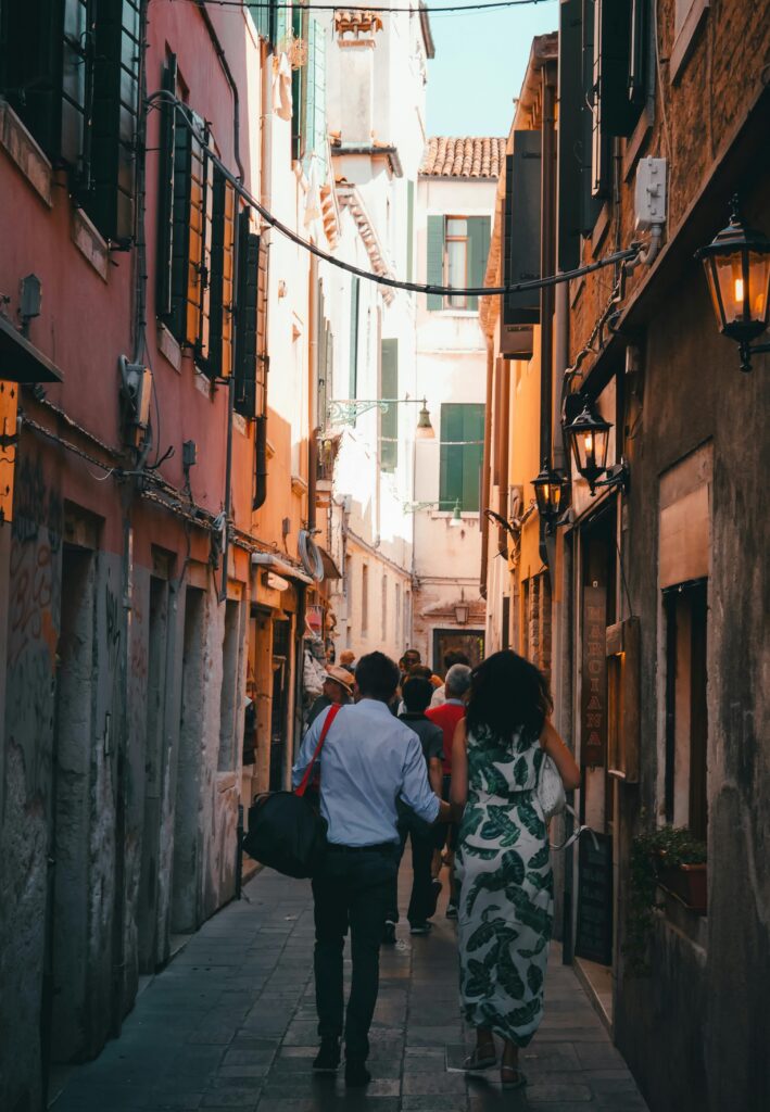 Travelers walking through a narrow historic street in a European city
