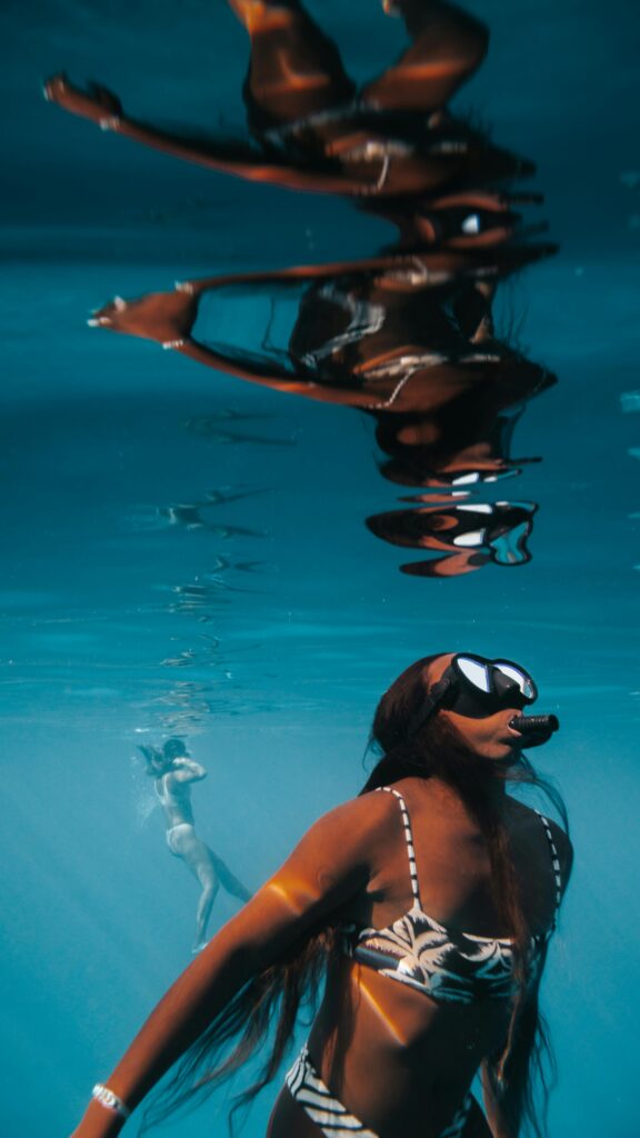 Swimmer gliding underwater in clear blue water during a travel experience